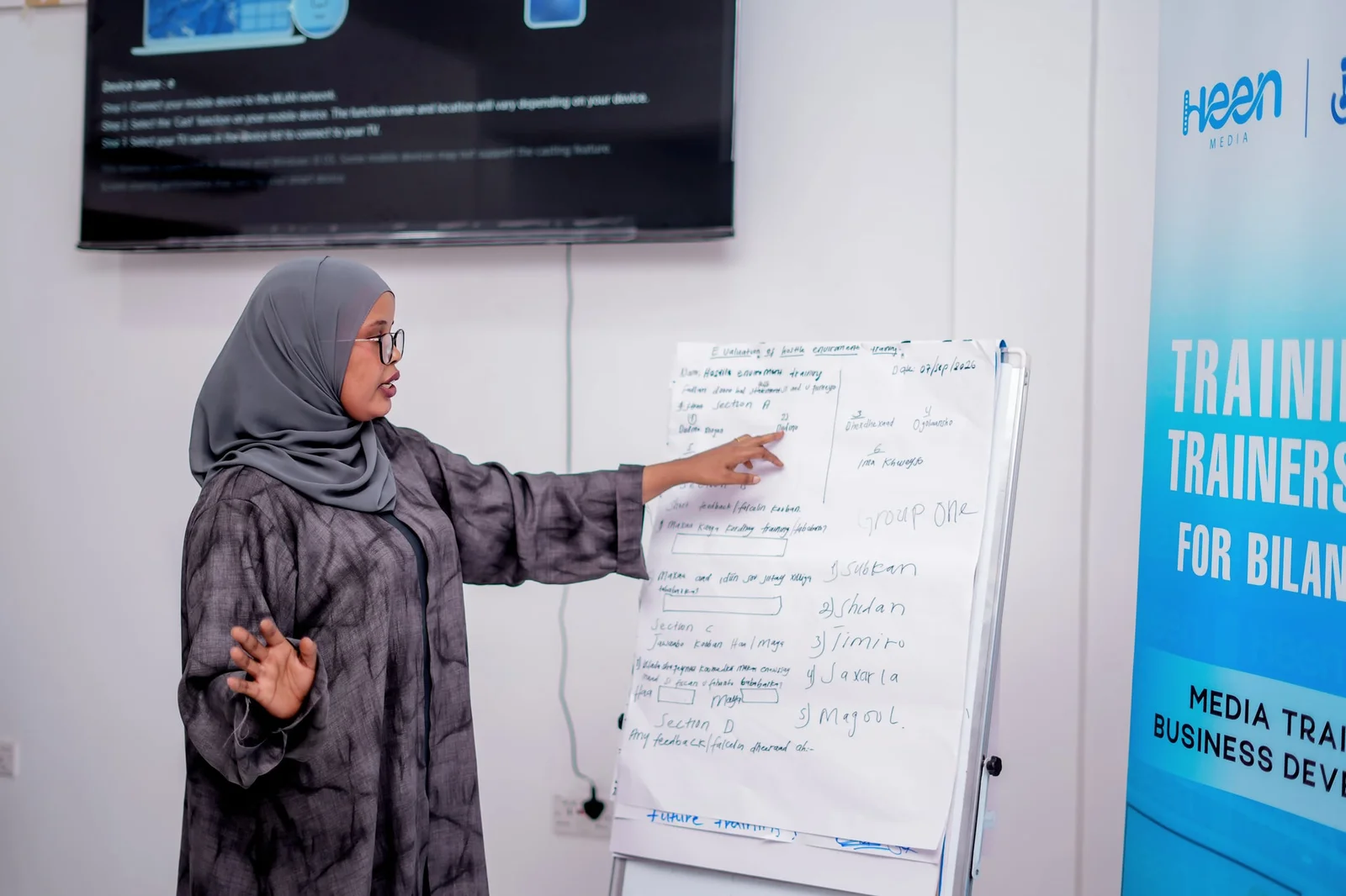 A participant presenting group findings on a flipchart during the Training of Trainers.
