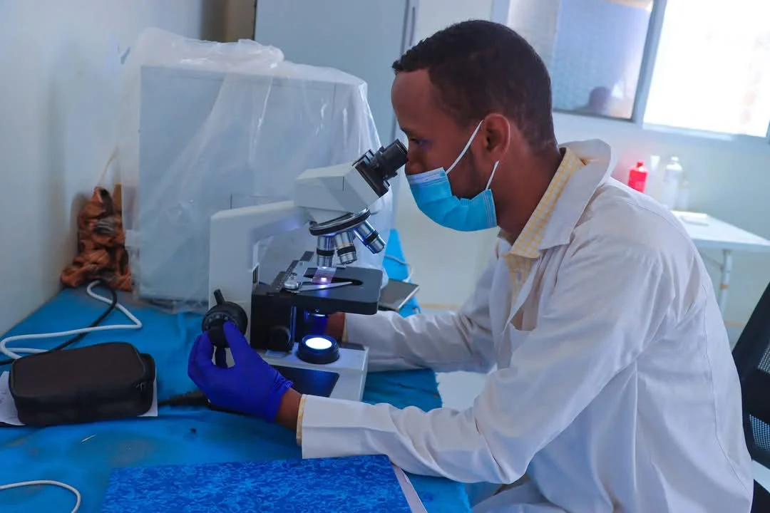 A laboratory worker using a microscope at Hudur Hospital in Somalia.